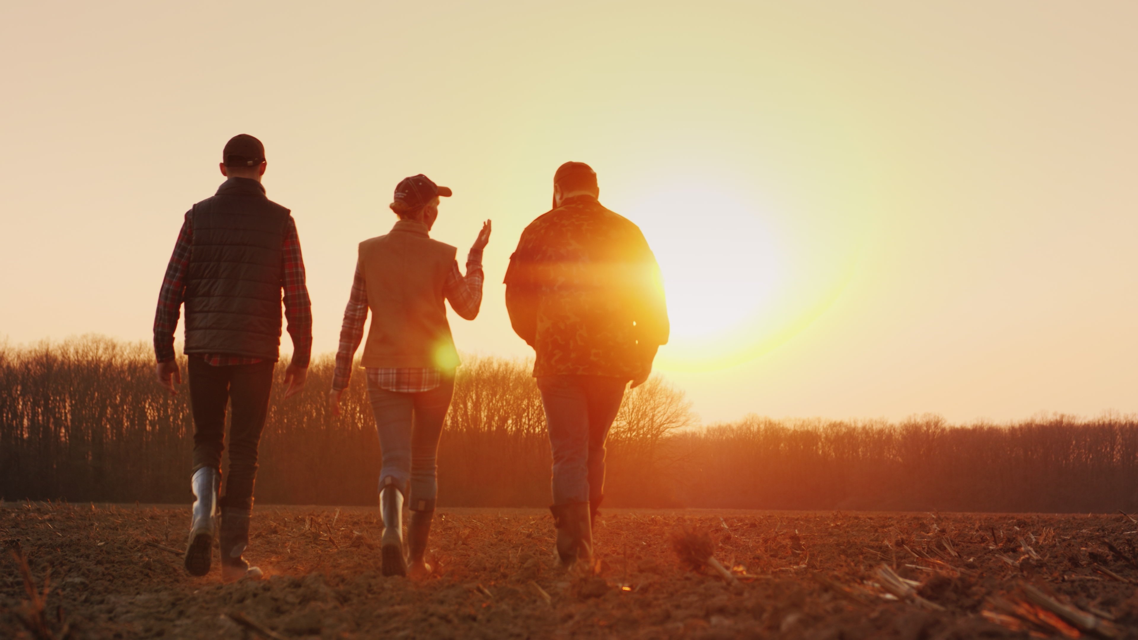 three farm employees walking towards field